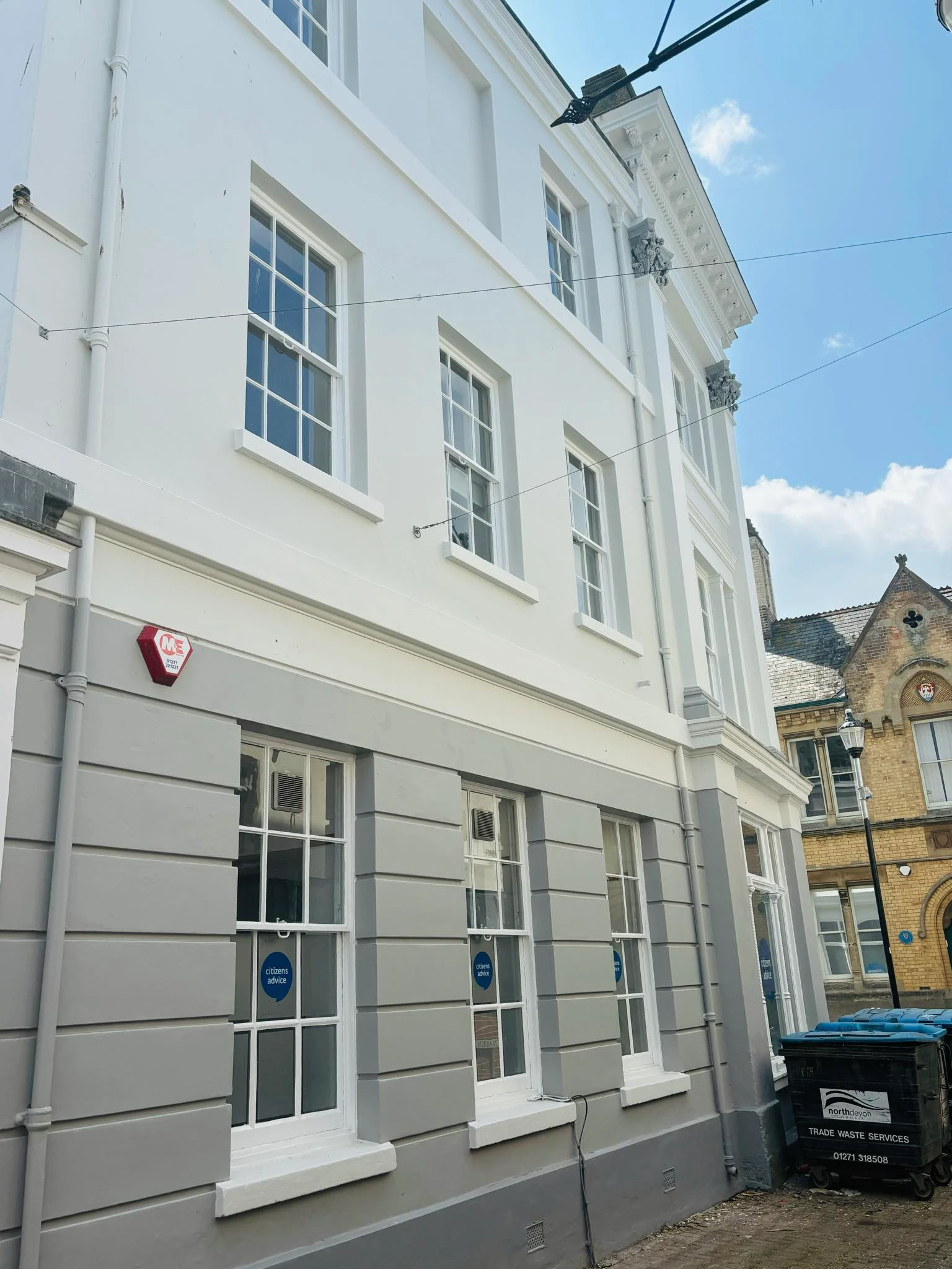 White and gray painted exterior of Bridge Buildings in Barnstaple with multiple windows