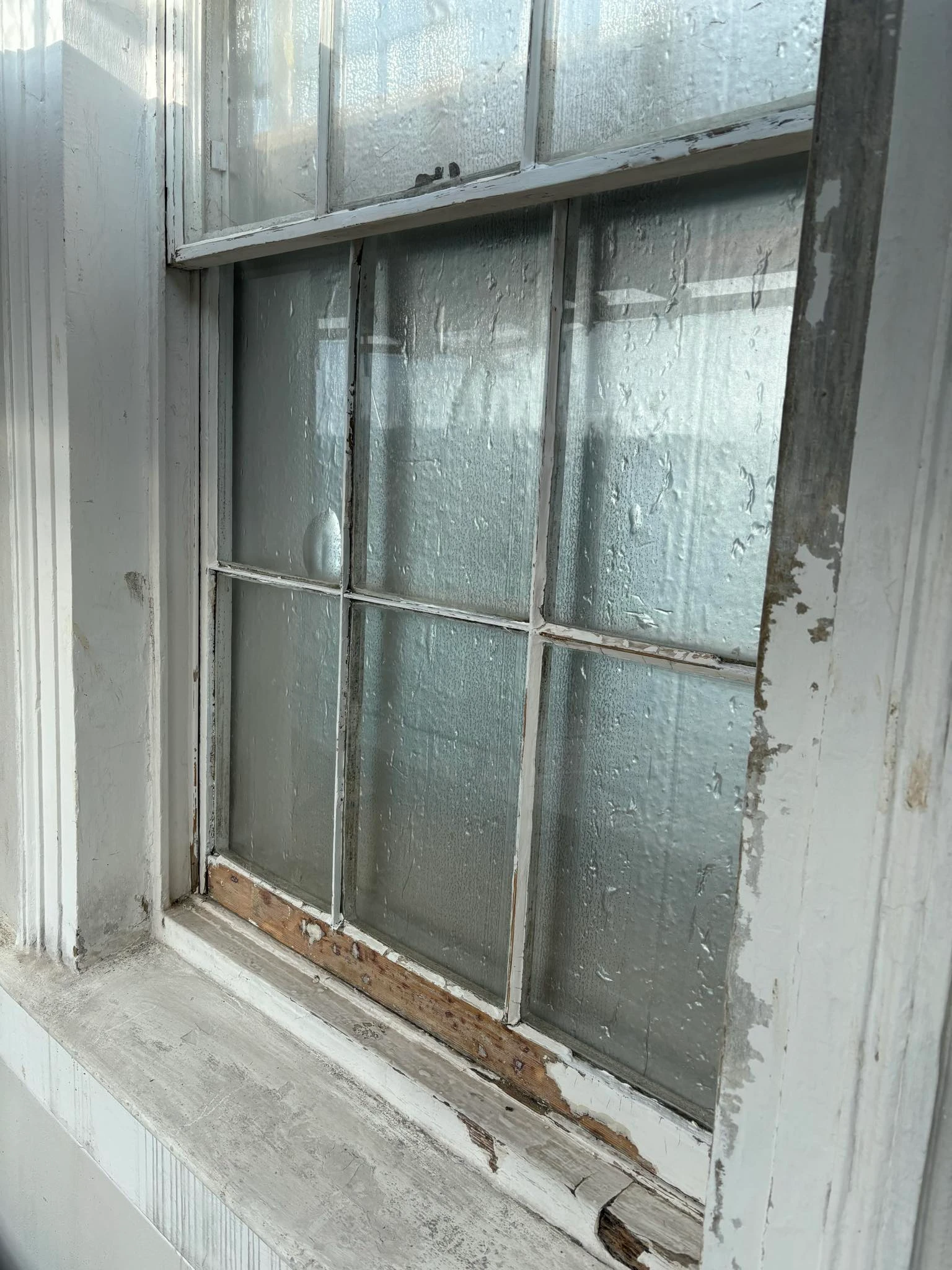 Close-up of weathered window frame with peeling paint before restoration