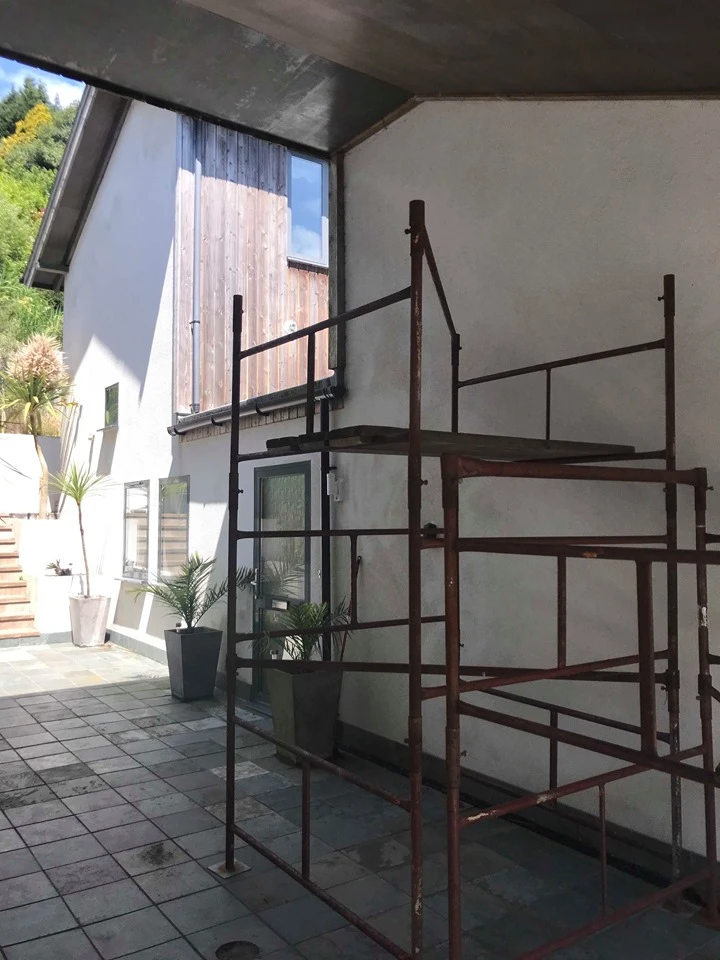 The Fernery exterior with scaffolding, white walls and wooden cladding