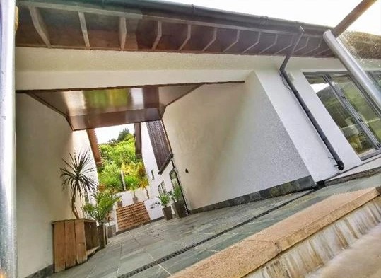 The Fernery covered entrance area with white walls and wooden ceiling