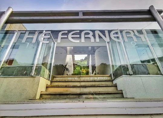 The Fernery entrance with glass frontage and signage showing steps leading to the entrance