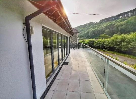 The Fernery terrace with glass balustrades overlooking scenic river and hills