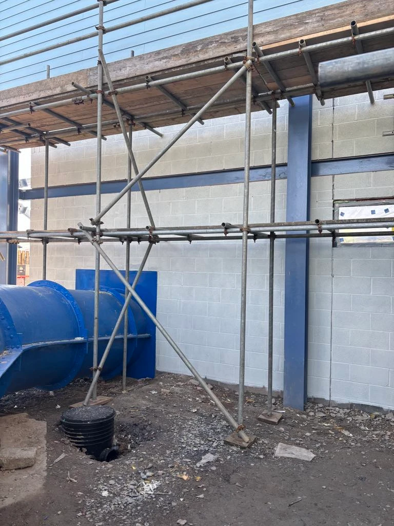 Scaffolding against white wall with blue water slide at Ruda Holiday Park