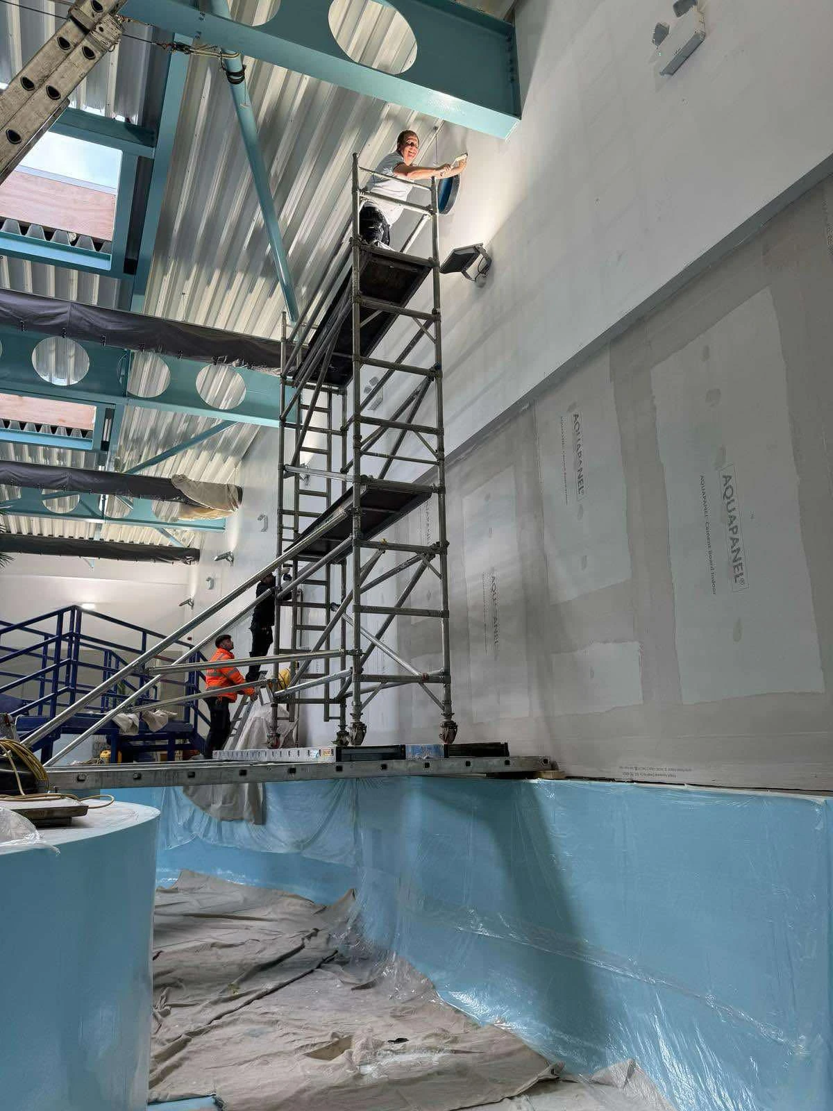 Interior pool area with scaffolding for painting high walls at Ruda Holiday Park