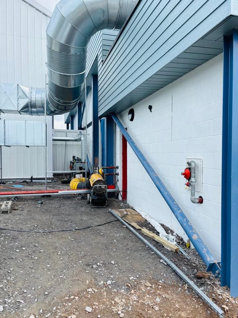 Exterior with white walls, blue trim and ventilation system at Ruda Holiday Park