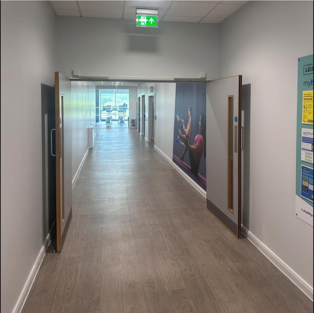 Tarka Leisure Centre hallway with bright freshly painted walls and modern wood-look flooring
