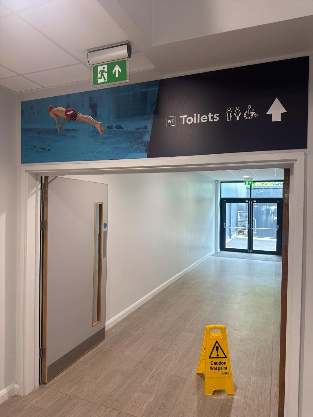Tarka Leisure Centre completed hallway with modern signage and wet paint caution sign