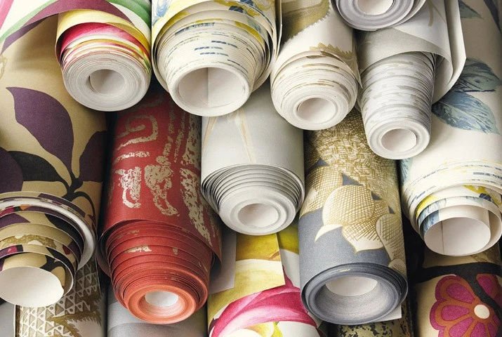 Collection of colorful wallpaper rolls with various patterns and designs