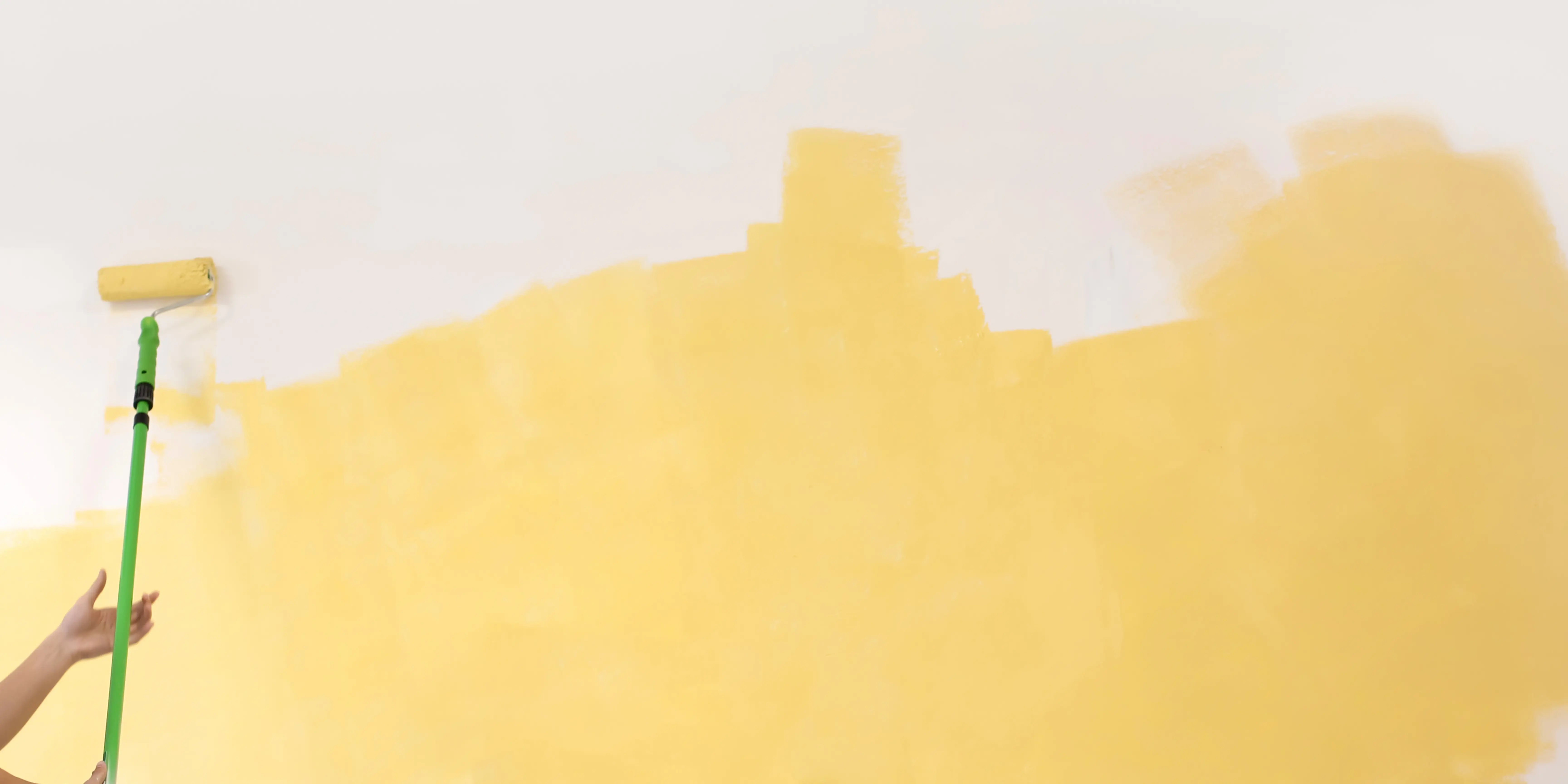 Painting a wall yellow with a roller